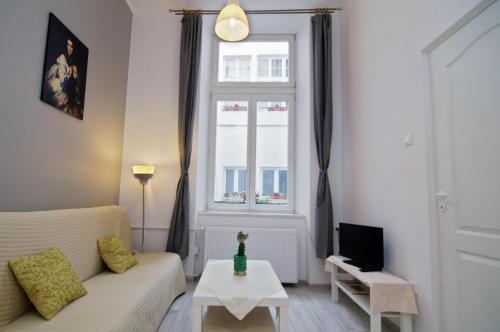 a living room with a couch and a window at Pokoje Gościnne Unikat - Self check in in Kraków