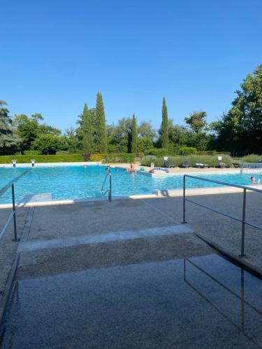 une grande piscine avec des gens dans l'eau dans l'établissement Les Papillons, à Verteillac