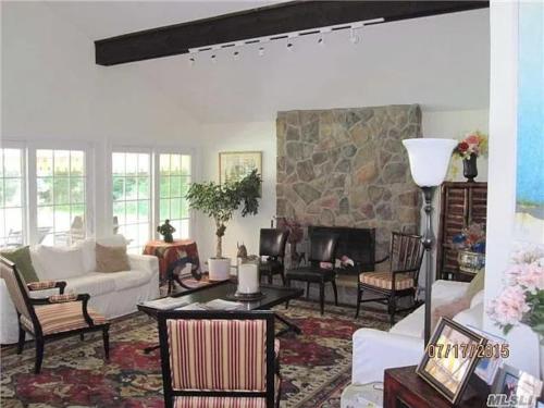 a living room with white furniture and a stone fireplace at 572) Large 3 bedroom with a gorgeous pool 