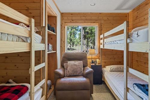 a bedroom with bunk beds and a chair and a window at Mallard Manor Hot Tub in Duck Creek Village
