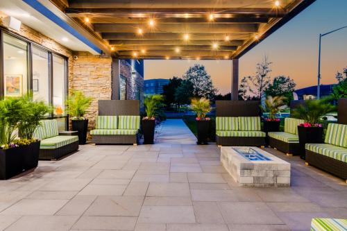 an outdoor patio with couches and plants at Home2 Suites By Hilton Bolingbrook Chicago in Bolingbrook