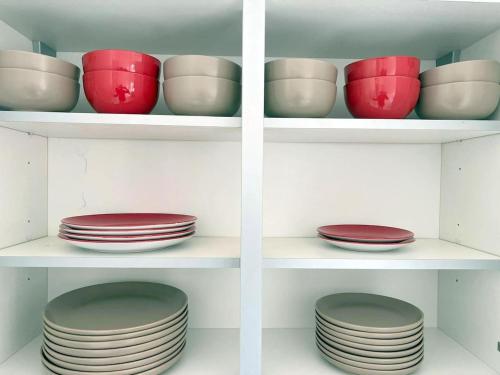 a bunch of bowls and plates sitting on shelves at Modern 8 bedroom House in South London in Mitcham