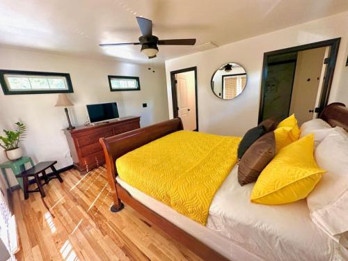 a bedroom with a bed with yellow sheets and a ceiling fan at HOUSE OF ROCK - DOWNTOWN, RUPP ARENA, KEENELAND, HORSE PARK in Lexington