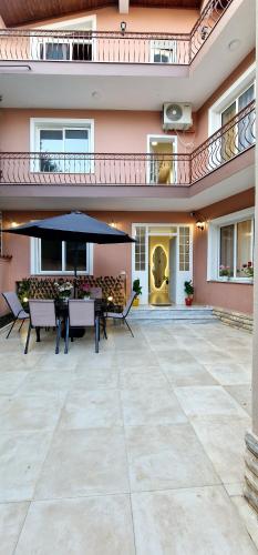 a patio with a table and an umbrella at Juar Villa - Modern Apartments in Tirana