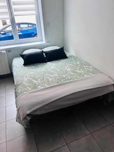 un lit avec deux oreillers dessus dans une chambre dans l'établissement Studio proche de la CNPE, à Gravelines