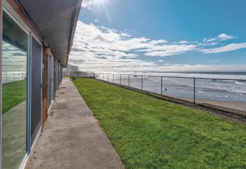 a walkway next to a building next to the ocean at Oceanfront Suite - Ground Floor in Lincoln City
