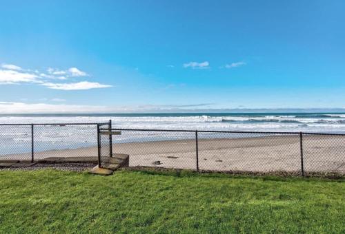 a view of a beach with a fence and the ocean at Oceanfront Suite - Ground Floor in Lincoln City