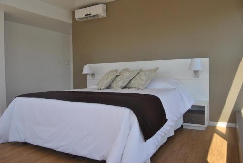 a bedroom with a large white bed with pillows at Hotel Castilla in Punta del Este