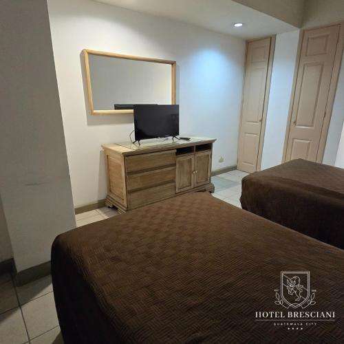 a hotel room with two beds and a mirror at Hotel Bresciani in La Aurora