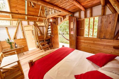 a bedroom with a bed in a wooden house at Finca Ecológica El Maco in San Agustín