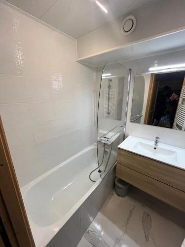 une salle de bain avec un lavabo, une baignoire et un miroir dans l'établissement Résidence Neves - VAL THORENS STUDIO 4 PERSONNES DANS QUARTIER VIVANT MAE-7545, à Val Thorens