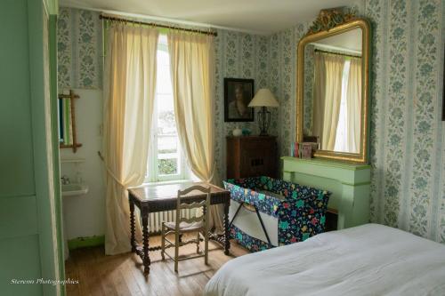 une chambre avec un lit, un bureau et un miroir dans l'établissement Grande maison familiale - Plage du Val-André, à Pléneuf-Val-André