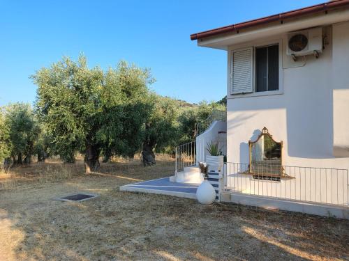 a house with a gate and a yard with trees at L'olivo - Meridiana case al mare in Mattinata
