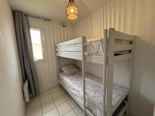 Cette chambre dispose de lits superposés avec deux lits superposés et une lampe. dans l'établissement Douceur de vivre en Provence, à Saint-Saturnin-lès-Avignon