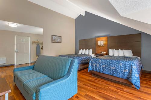 a hotel room with two beds and a couch at Econo Lodge Inn & Suites Gatlinburg at the Convention Center in Gatlinburg