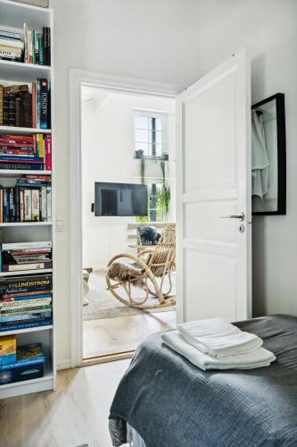 ein Schlafzimmer mit einer Tür, die sich zu einem Wohnzimmer mit einem TV öffnet in der Unterkunft Step Through The Gate And Feel Peace In The Woods in Silkeborg