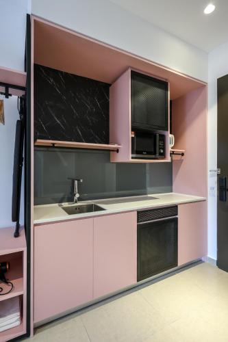 a kitchen with a sink and a microwave at Paxtonz Exsim By NexxField in Petaling Jaya