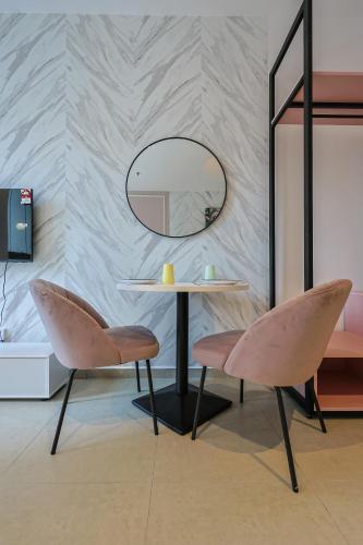 a table and two chairs in front of a mirror at Paxtonz Exsim By NexxField in Petaling Jaya