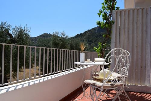 a table and a chair on a balcony at L'olivo - Meridiana case al mare in Mattinata