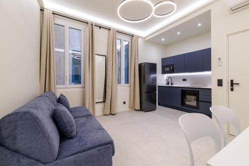 un salon avec un canapé bleu et une cuisine dans l'établissement PLACE MASSENA Coulée Verte, à Nice