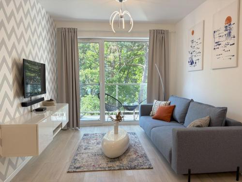 salon z kanapą i telewizorem w obiekcie Lucky40 - Apartament z widokiem na morze, SPA gratis, Dwie Sosny w mieście Ustronie Morskie