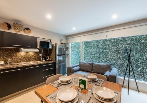 a kitchen and living room with a table and a couch at Cicerón 612 Aparthotel Polanco in Mexico City