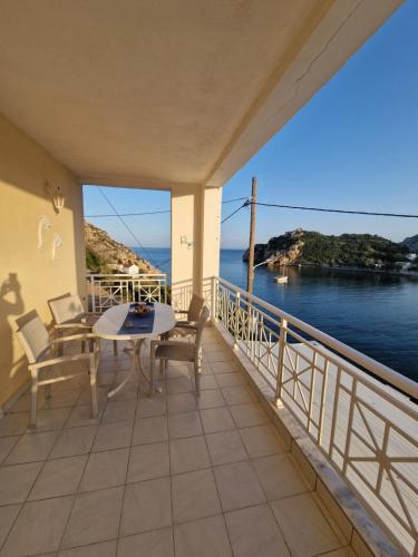 a balcony with a table and chairs and the ocean at Emporios Mansion in Emporeios