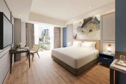 a hotel room with a bed and a desk and a desk at Four Points by Sheraton Bekasi in Bekasi