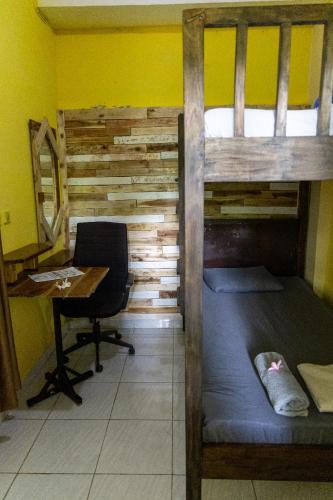 a room with a bunk bed and a desk and a chair at Happy Spiritus Guethouse Tabanan in Tabanan