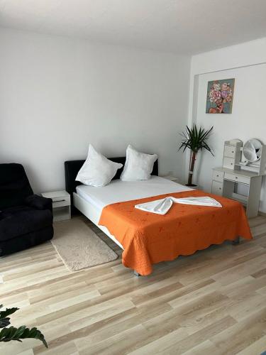 a bedroom with a bed with an orange blanket at Studio 1 & Studio 2 Aqua in Eforie Nord