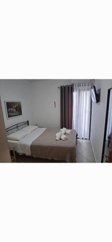 een slaapkamer met een bed met handdoeken erop bij Thea Marina ! in Livadion