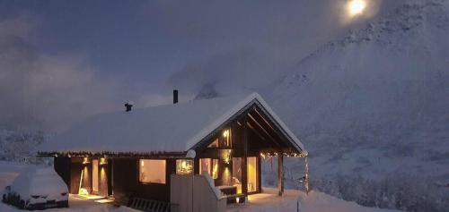 a house with a snow covered roof in the snow at Cozy Family Cabin In Uniquely Situated Hiking Area in Indre Standal