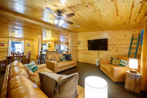 Una sala de estar con un sofá y un ventilador de techo. en Outlaw Rose Cabin - Family Fun with Hot Tub, en Broken Bow
