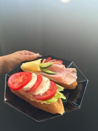 een broodje met vlees en groenten op een bord bij DH Duomo VI studio in Košice