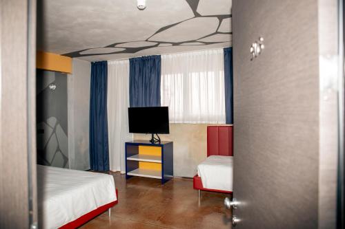 a room with two beds and a television in it at K MODERN HOTEL in Peschiera del Garda