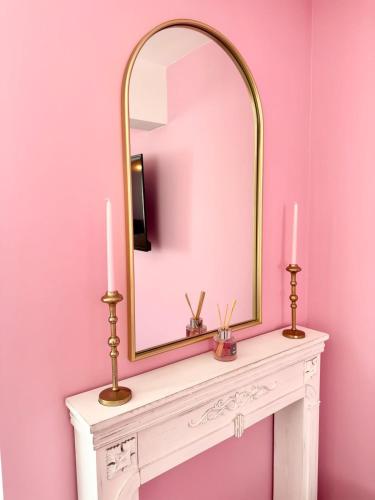 a mirror on top of a white table with two candles at Studio rose & spa Pause bien-être in Quéven