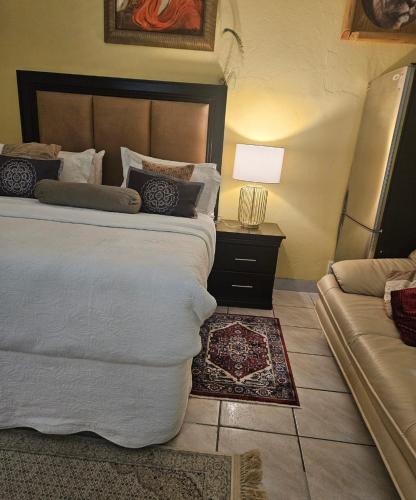 a bedroom with a large bed and a couch at RPG Corporate Unit in Johannesburg