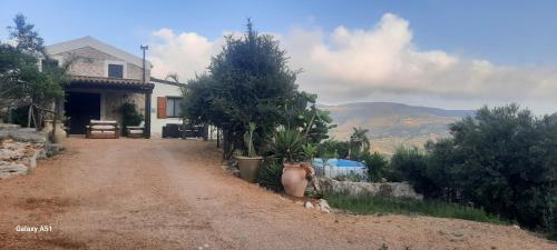 a dirt road in front of a house with trees at Al ficodindia in Scopello
