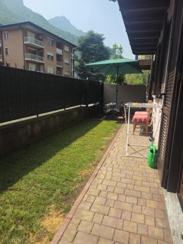 a patio with a table and an umbrella on a lawn at Casa Tiziana in Sovere