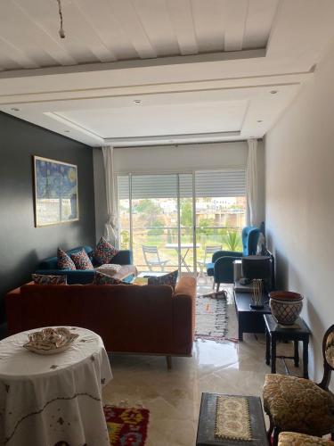 a living room with a couch and a table at Appartement Kettani bouznika in Bouznika
