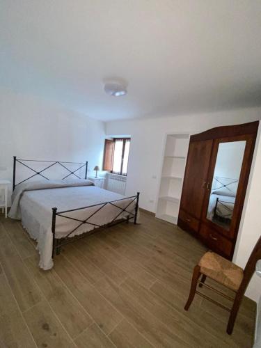 a bedroom with a bed and a chair and a mirror at Casa Saotta in Collimento