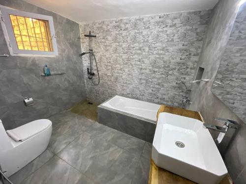 a bathroom with a sink and a bath tub at ParadisPlage, 1 minute de la mer in Saly Portudal
