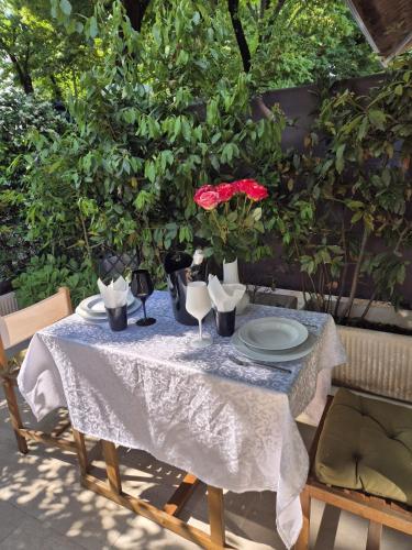 a table with a white table cloth and a red flower on it at Villa Joy Verona - Junior Suite in Verona