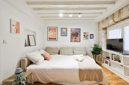 une chambre avec un grand lit et un canapé dans l'établissement Modern Parisian Retreat Cozy T2 in Paris 02, à Paris