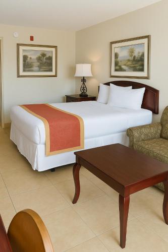 a hotel room with a large bed and a table at Serena Inn in Kissimmee