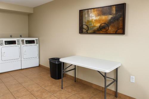 a kitchen with a white table and a washing machine at Serena Inn in Kissimmee