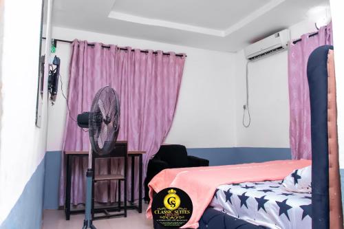 Schlafzimmer mit einem Bett und einem Ventilator in der Unterkunft Classic Chillout Suite in Ilorin