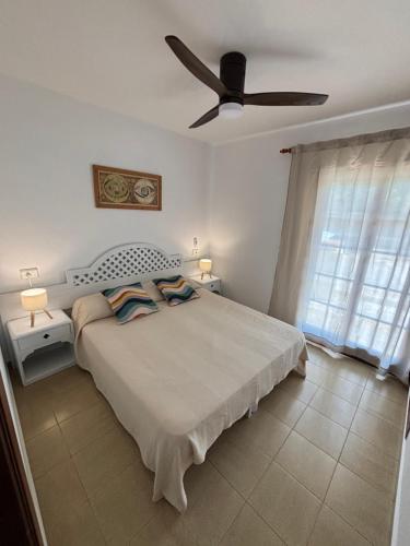 a bedroom with a bed and a ceiling fan at Apartamento costa Menorca in Cala en Bosc