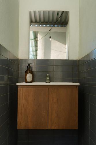 a bathroom with a sink and a mirror at The Duck Dive El Tunco in Tamanique