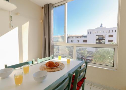 une salle à manger avec une table et une grande fenêtre dans l'établissement Palmera by Pom, parking, piscine, au Cap d'Agde